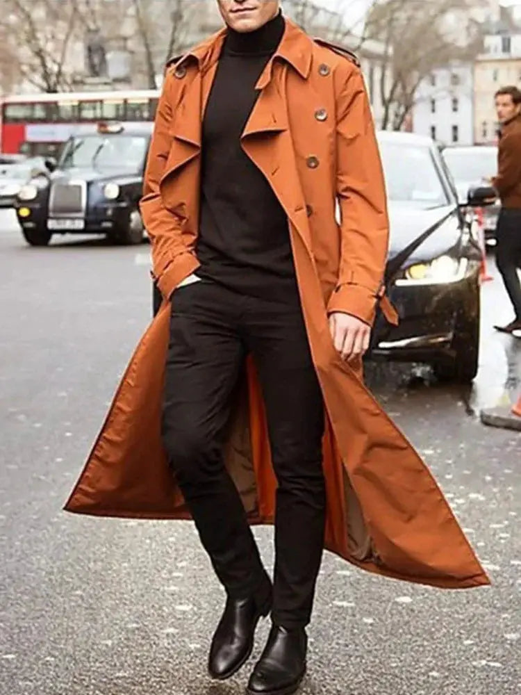 Men's orange-brown trench coat with epaulets, a long overcoat worn open over black outfit.