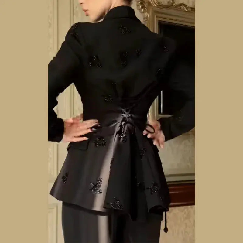 Women's black beaded peplum jacket set with waist-tie belt and wide-leg pants, back view