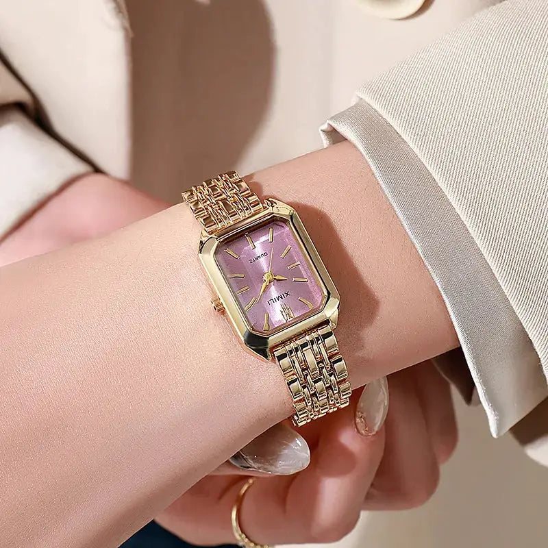 Simples Market luxury women's rectangle quartz watch with gold-tone bracelet and pink dial.