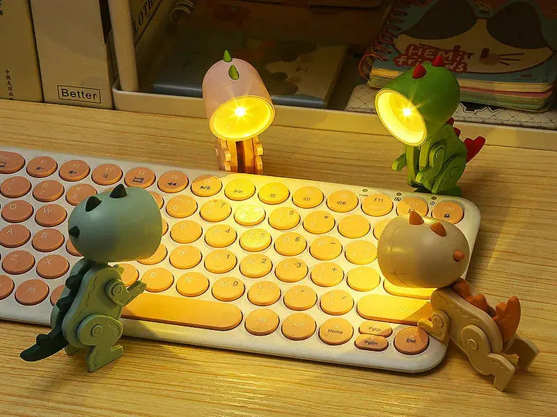Mini LED night lights; four cartoon hero figures sit on a keyboard, glowing warm yellow as desk lamps.