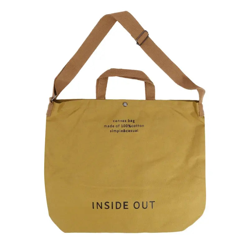 Canvas cross-body bag by Simples Market in mustard yellow with adjustable strap and short handles, large-capacity.