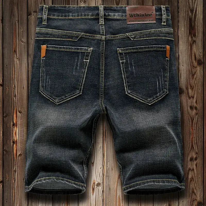 Simples Market men's denim shorts, dark indigo with leather patch and contrast stitching, back pockets.