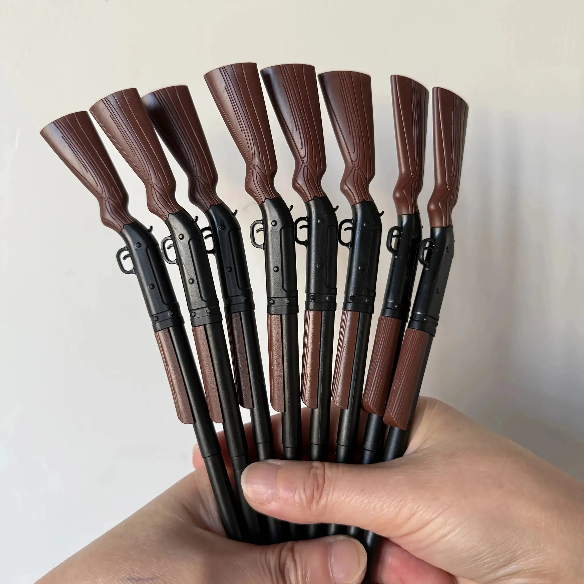 Gun-shaped ballpoint pen set; multiple brown-patterned grips on black bodies