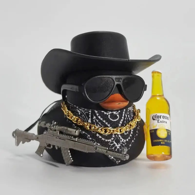 Cowboy rubber duck car ornament with black hat, big sunglasses, bandana, gold chain, rifle, beside Corona Extra beer bottle.