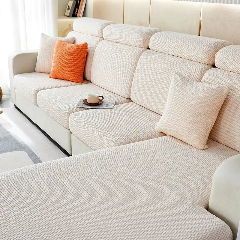 Jacquard sofa slipcover set on a beige sectional with matching cushions; stretchy protective furniture cover.
