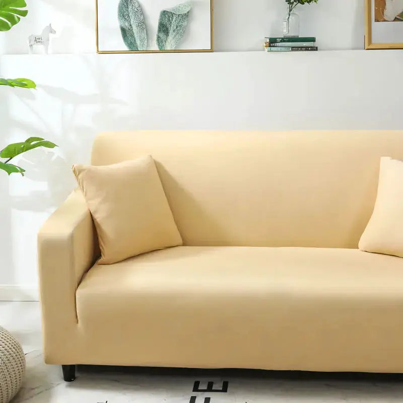 Beige stretch sofa slipcover on a modern sofa with matching cushions