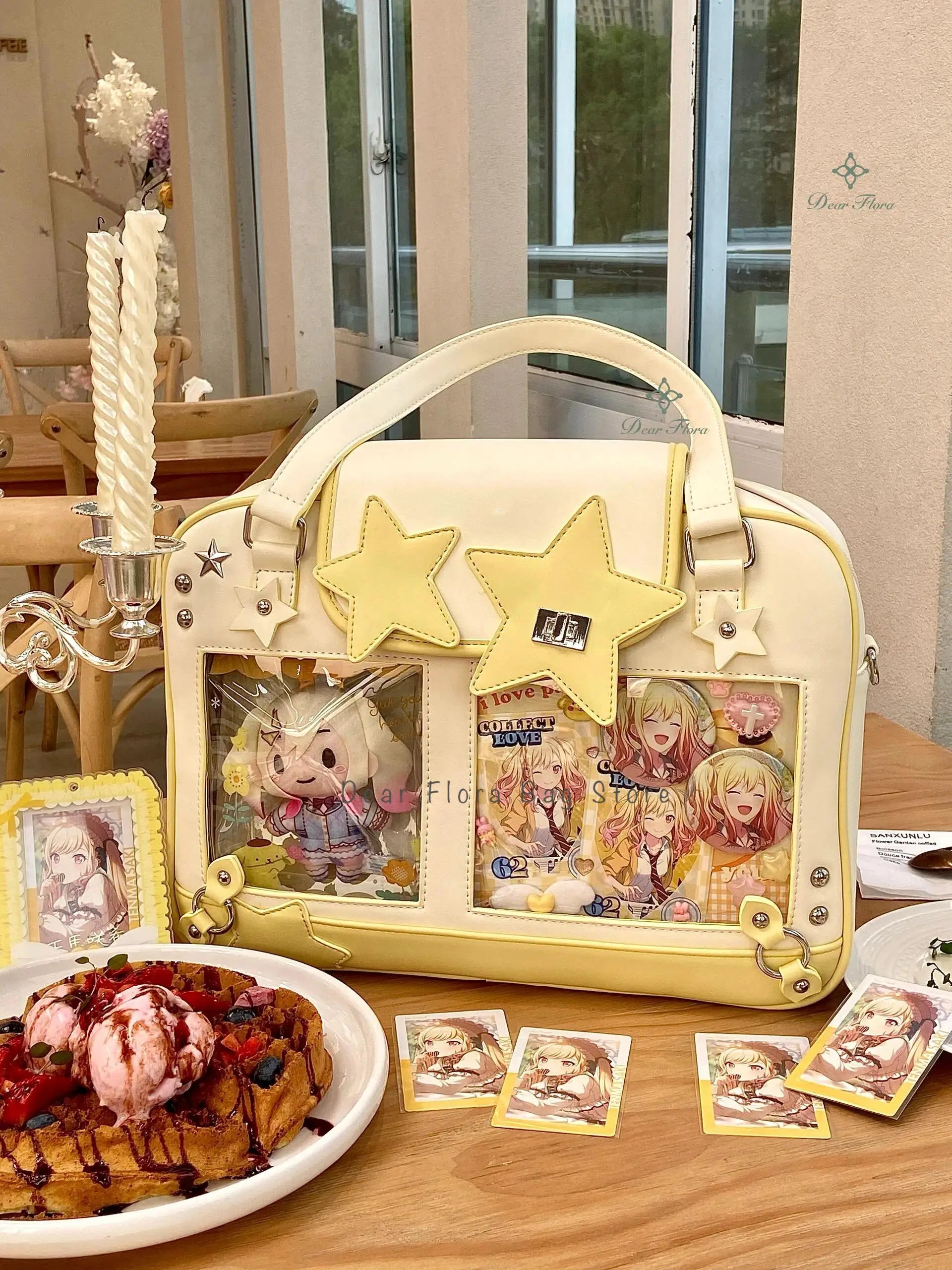 Pastel yellow star ita bag with transparent display pockets showing anime cards, crossbody purse