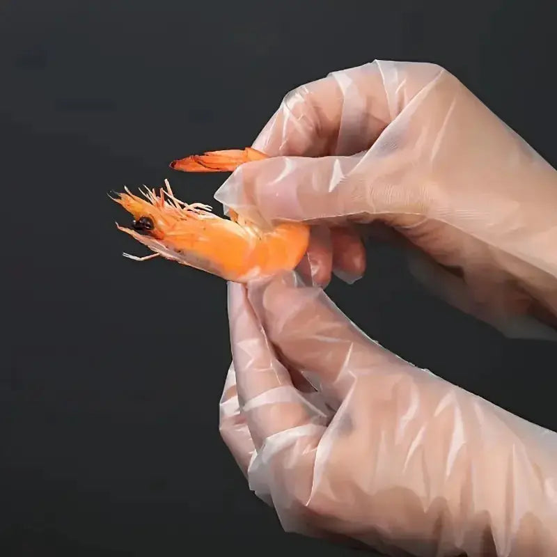 Clear disposable TPE gloves worn while peeling a shrimp