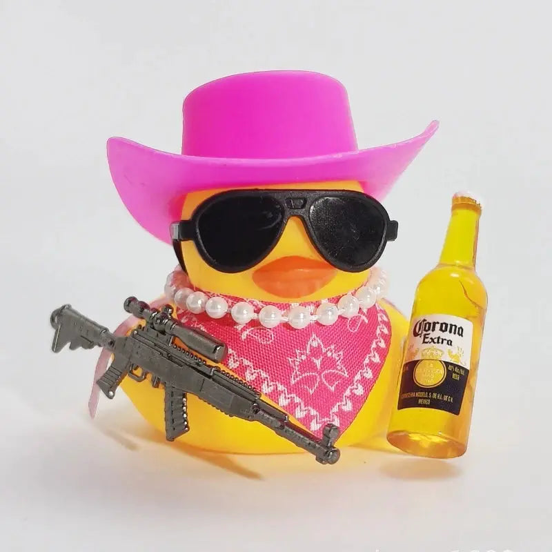 Cowboy rubber duck car ornament with pink hat, black sunglasses, bandana, pearl necklace, rifle, and Corona bottle