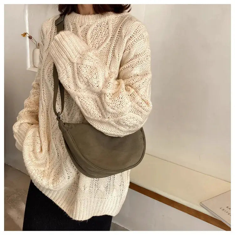 Casual nylon hobo crossbody bag in olive, with long strap worn by woman in a cream knit sweater