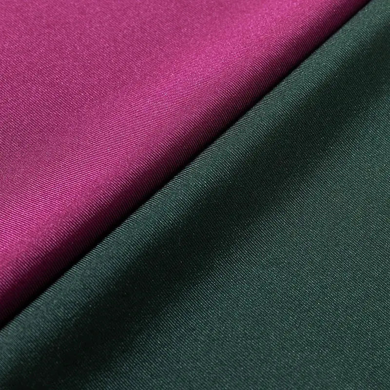 Two fabric swatches in magenta and forest green with smooth satin-like texture