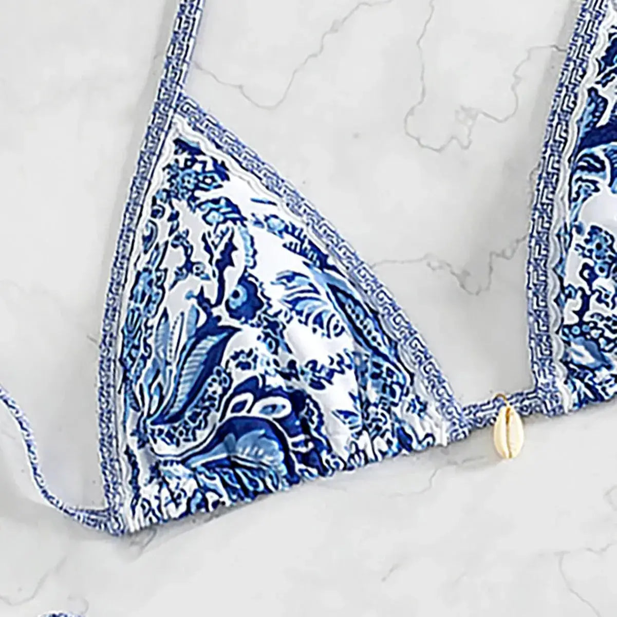 Blue floral print triangle bikini top with white base and shell charm