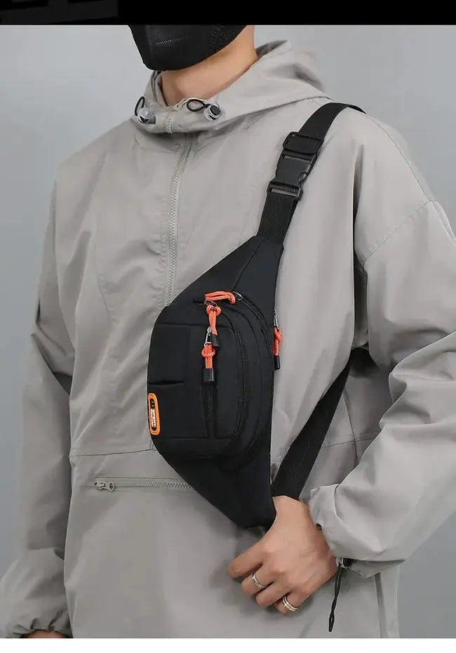 Oxford waterproof waist bag by Simples Market worn crossbody with orange zipper pulls.