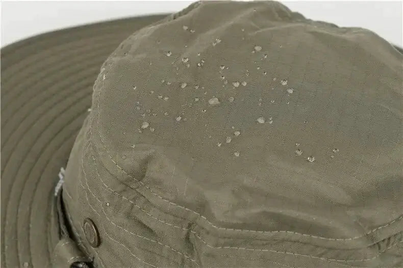 Khaki bucket hat with chin strap, water droplets on fabric.