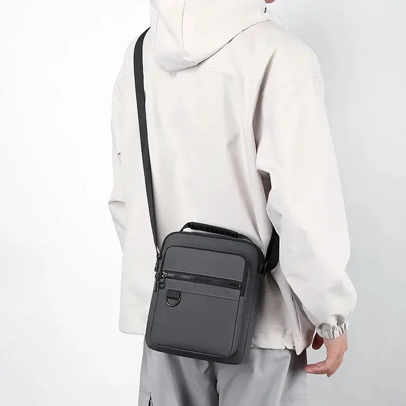 Messenger sling bag for men in gray with black strap, compact crossbody phone pouch.