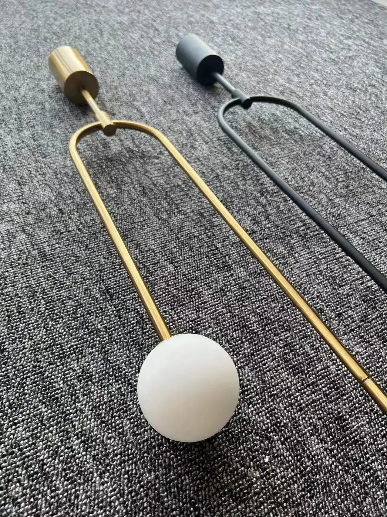 Modern glass ball pendant light by Simples Market, gold and black metal frames with frosted globe.