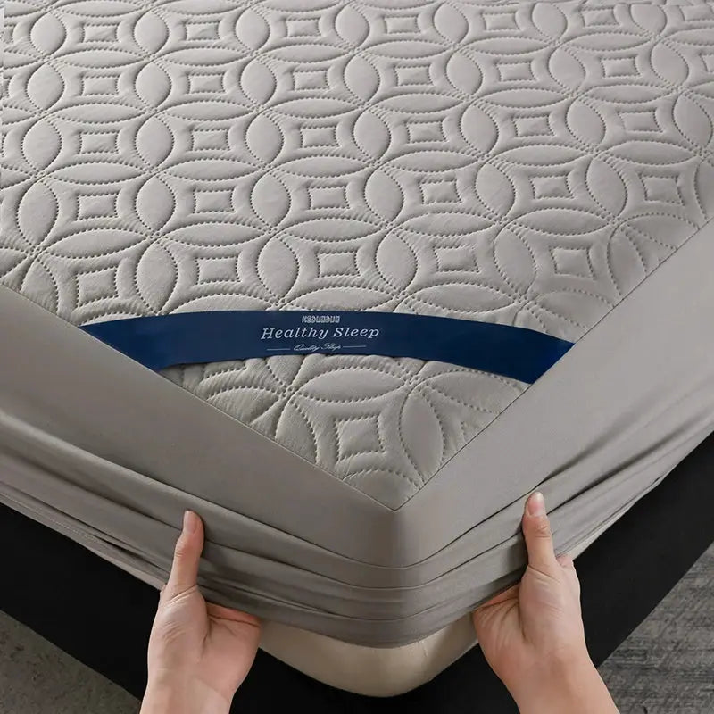 Mattress protector, grey quilted fabric with circular pattern and blue label, 30cm deep pocket