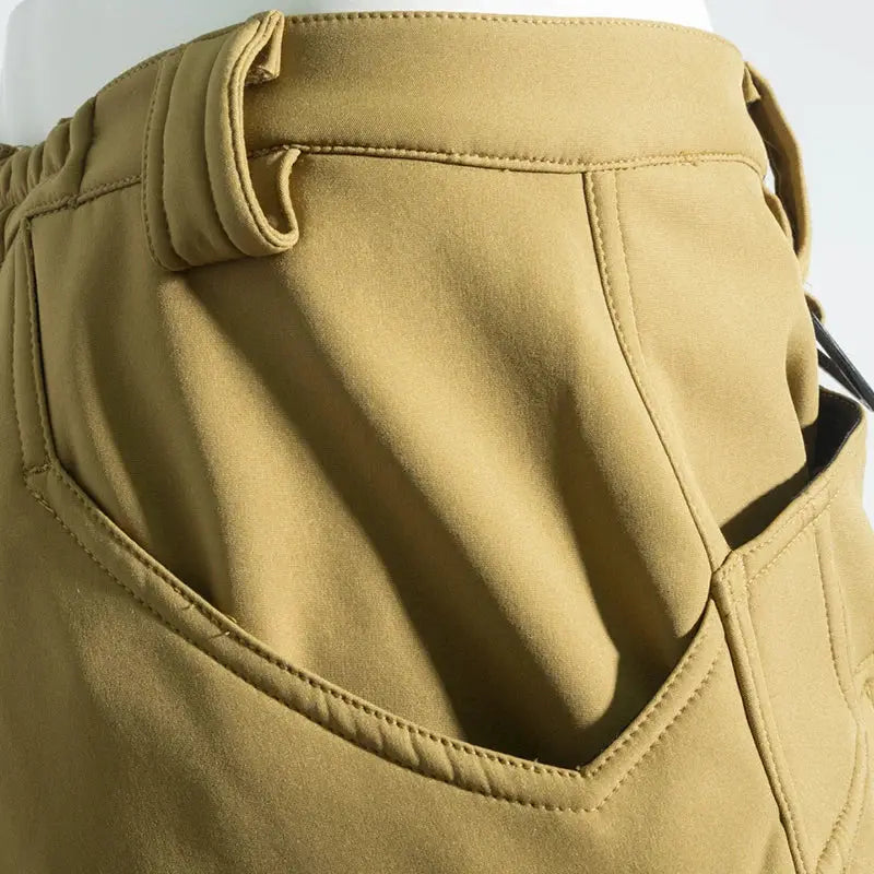 Men's cargo hiking pants in tan fleece-softshell fabric with belt-loop waist and cargo pocket.
