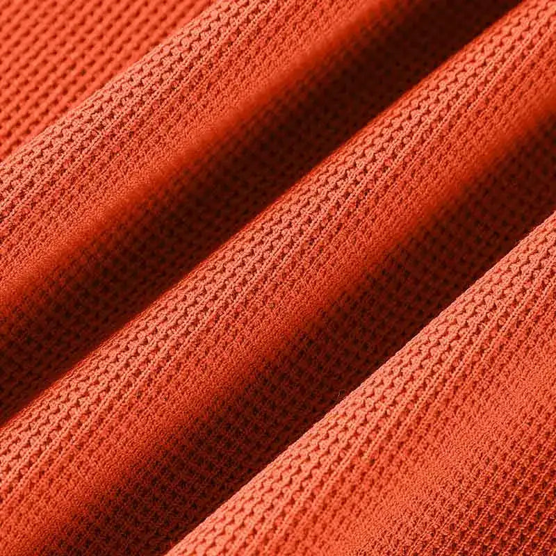 Men's short-sleeved polo shirt by Simples Market in bright orange, breathable textured knit fabric.
