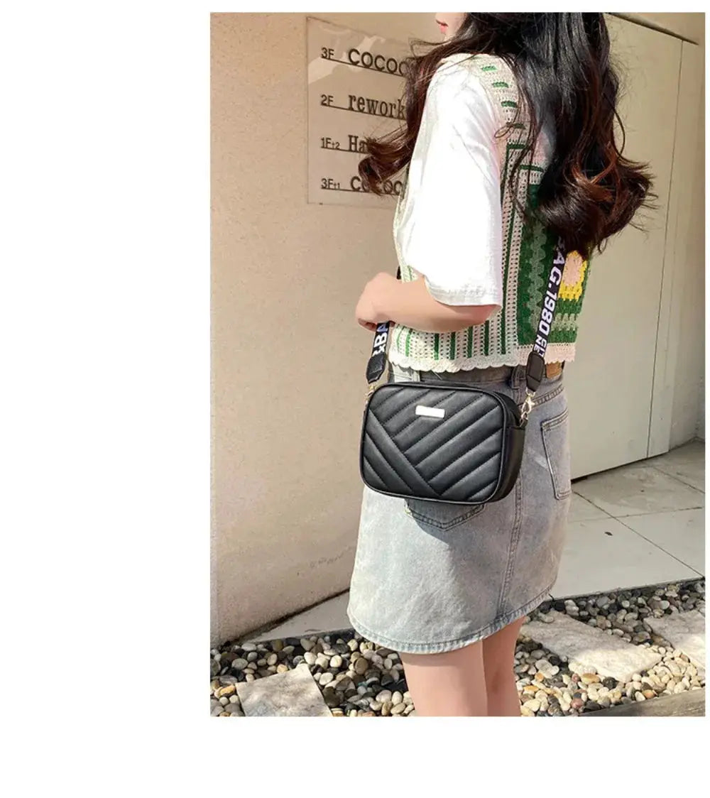 Shoulder bag black quilted crossbody with diagonal chevron stitching.