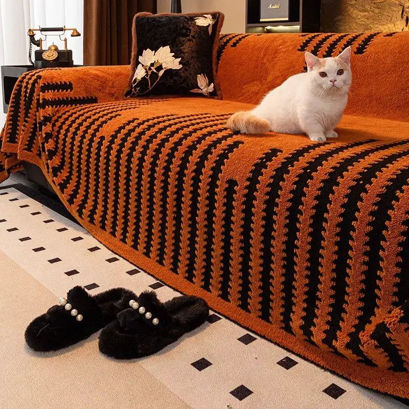 Thicken Warm Jacquard Tuffed Fleece Sofa Towel by Simples Market; orange-black sofa throw with 2 black pearl-strap slippers nearby