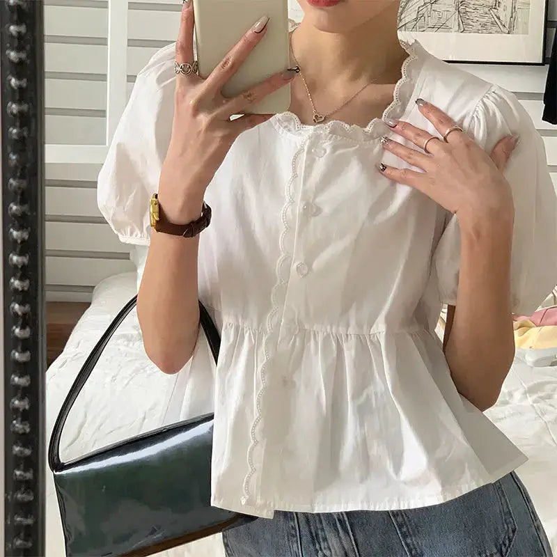 White women's short puff-sleeve blouse with scalloped lace trim and peplum waist