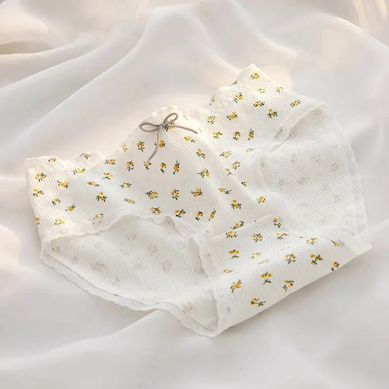 White cotton women's briefs with tiny yellow floral pattern, mid-waist and lace trim