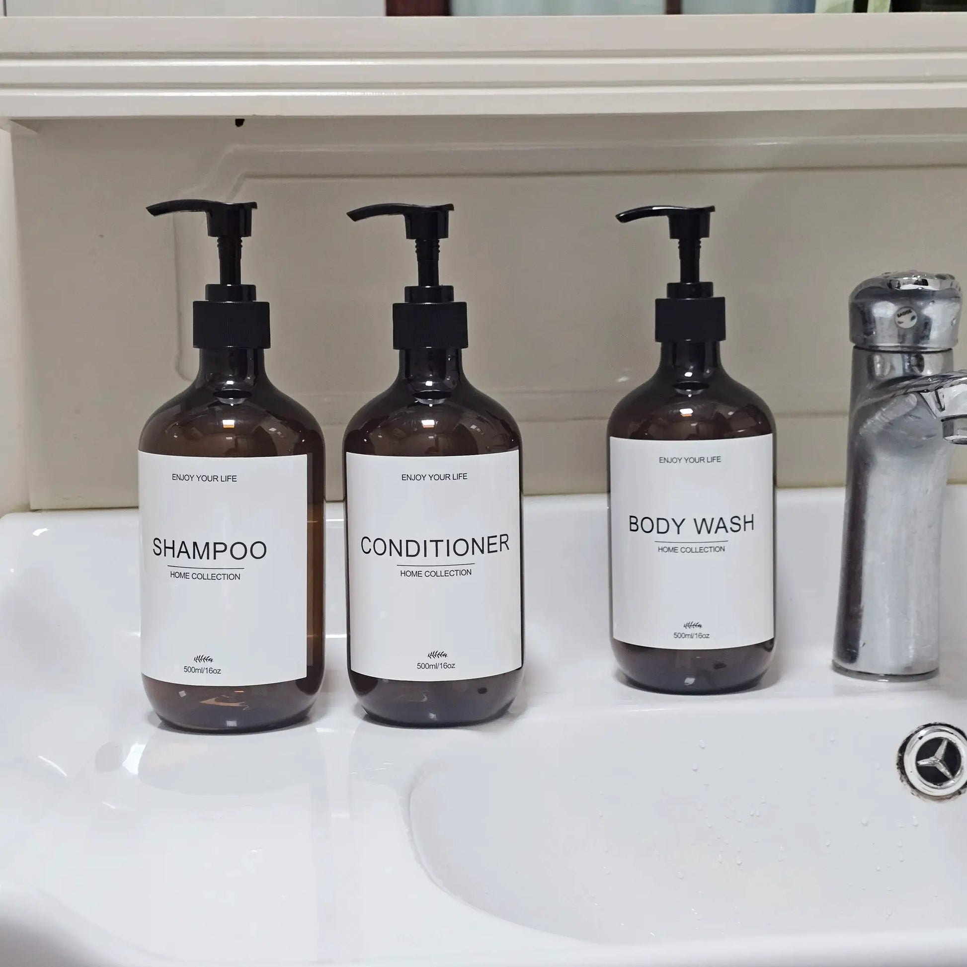 Three brown 500ml pump dispenser bottles labeled SHAMPOO, CONDITIONER and BODY WASH with black pumps