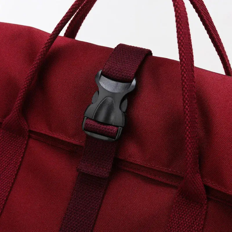 Backpack, red with buckle closure, large-capacity, fits 14-inch laptop.