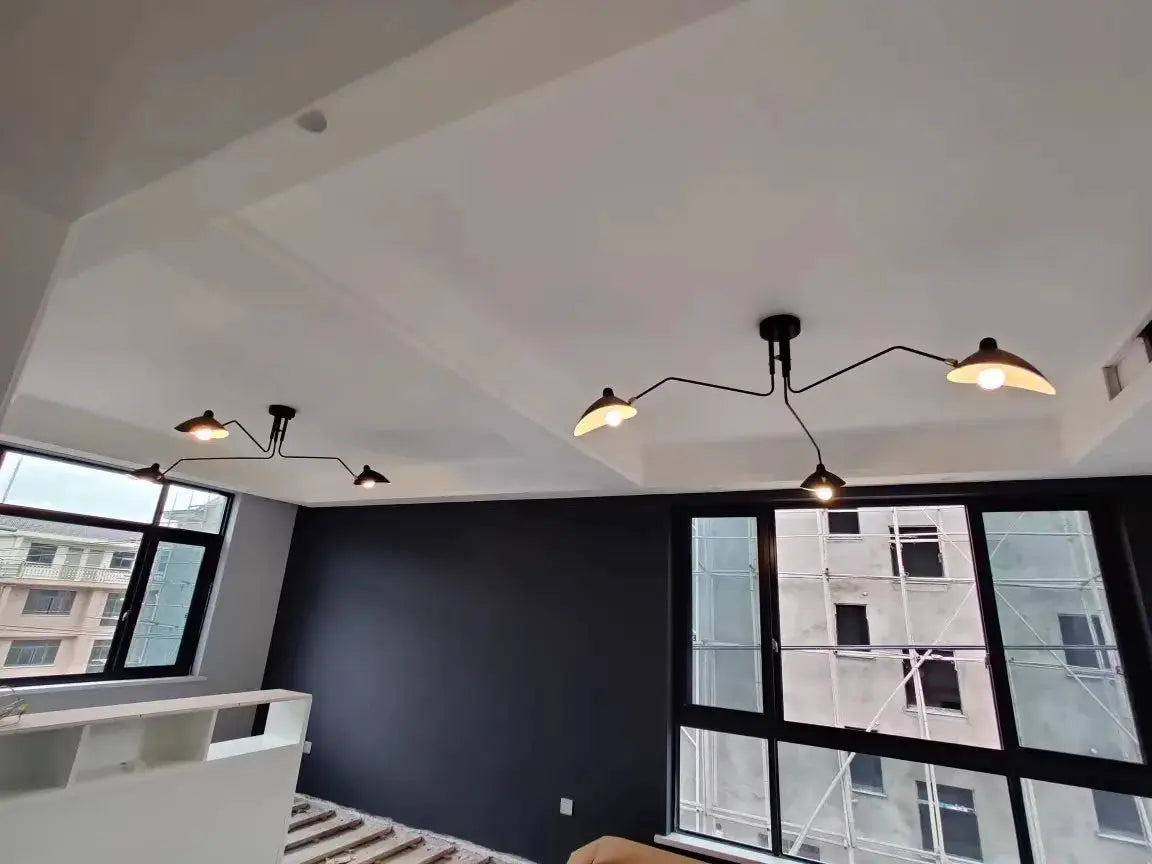 Simples Market spider pendant light with black metal arms and beige shades in a modern living room.