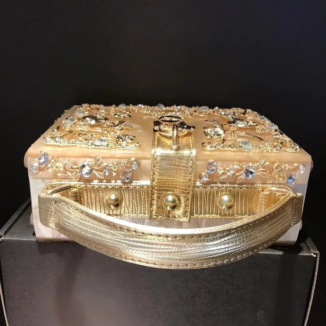 Evening bag by Simples Market, pearl-beige crystal box clutch with gold-tone metalwork and jeweled detailing.