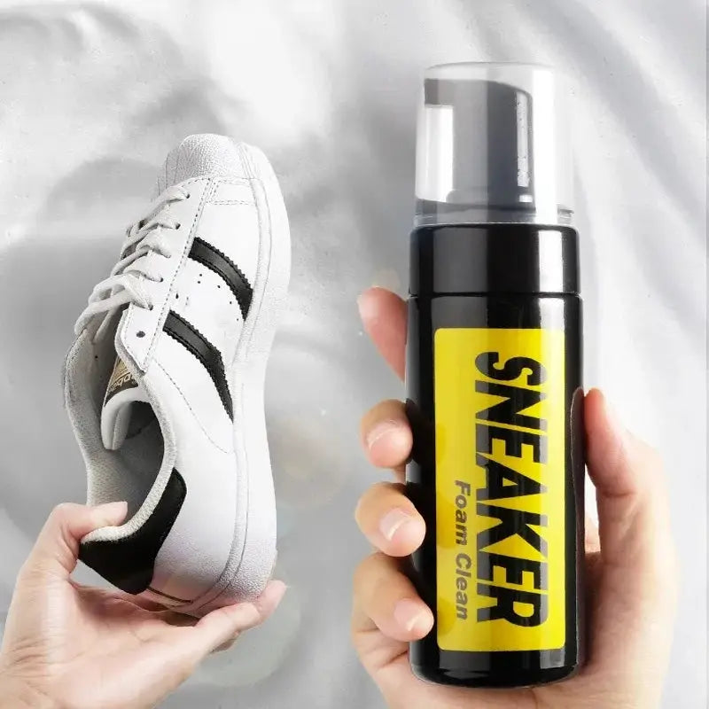 Sneaker cleaner foam bottle 150ml by Simples Market beside white sneakers with black stripes