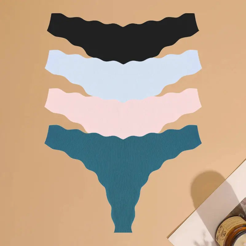 Four-pack of women's seamless thong underwear in black, white, pink and teal; ultra-soft, breathable, low-rise G-string.