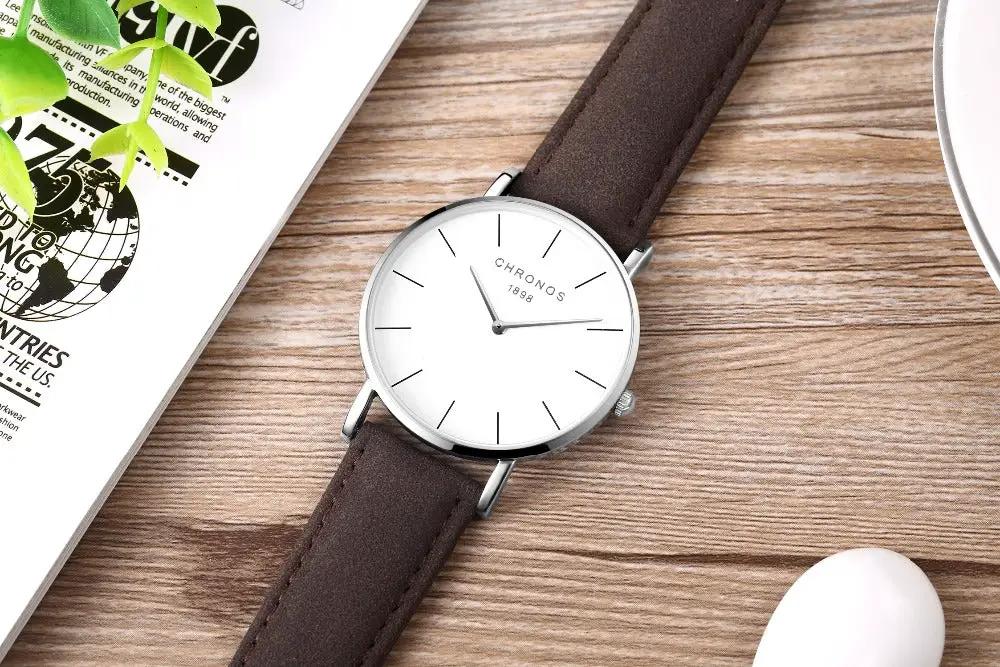 CHRONOS watch with white dial, silver case, brown leather strap; unisex minimalist quartz.