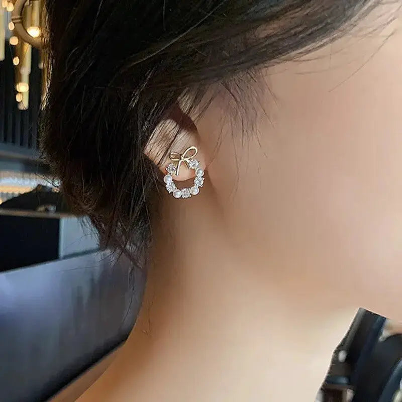 Hollow round rhinestone bow ear stud earrings in gold-tone for women.