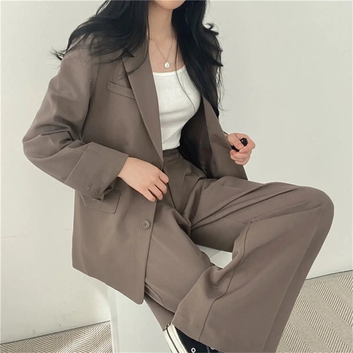 Women's taupe suit jacket and wide-leg pants set with white top, office-ready ensemble.