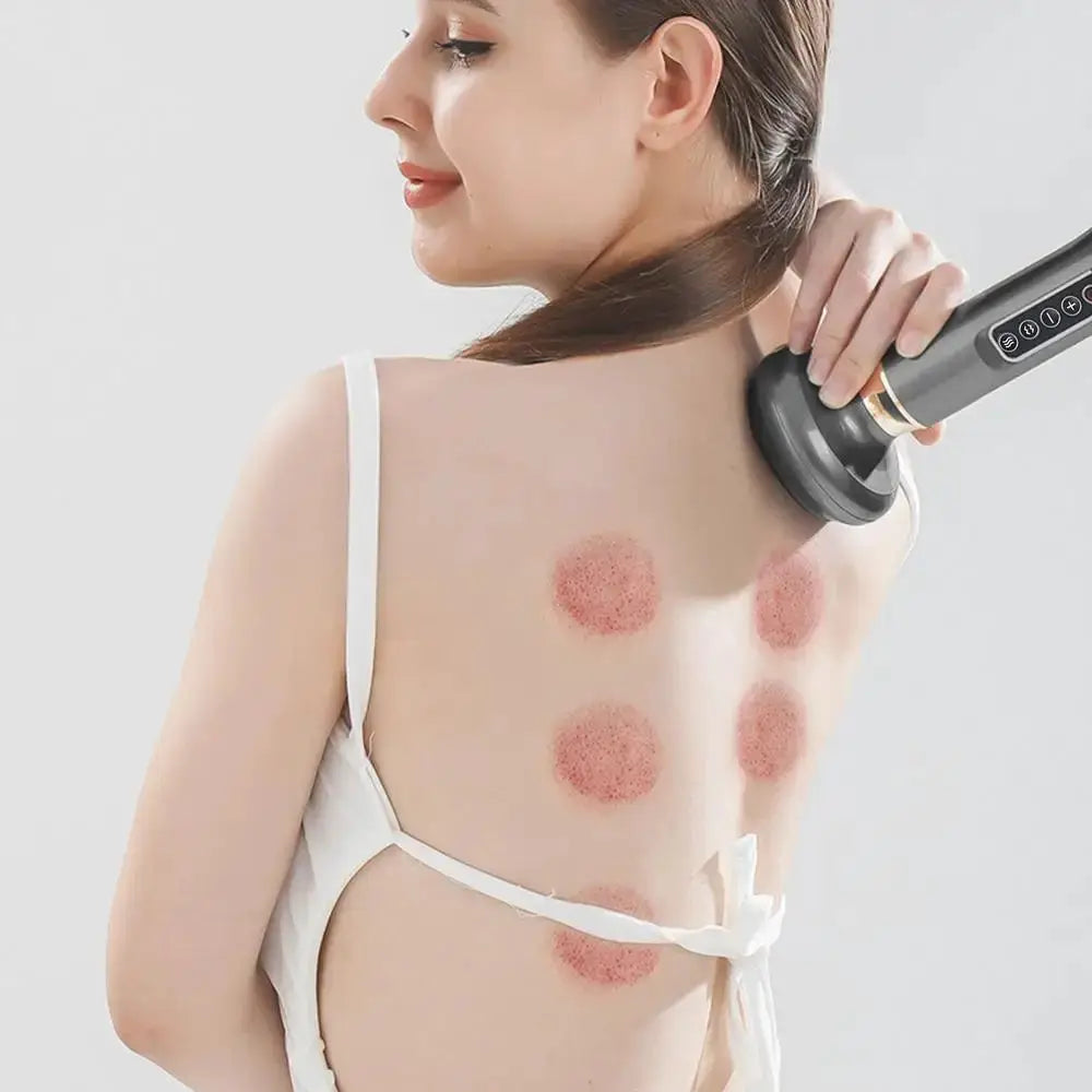 Simples Market handheld anti-cellulite massager with hot compress; grey device used on back with red circular marks.
