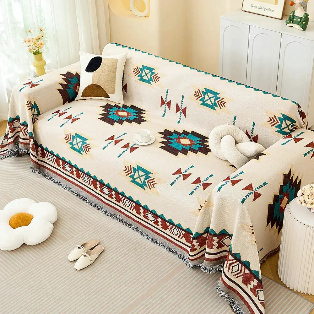 Sofa throw blanket by Simples Market in cream with teal, brown, rust geometric pattern and fringed edges