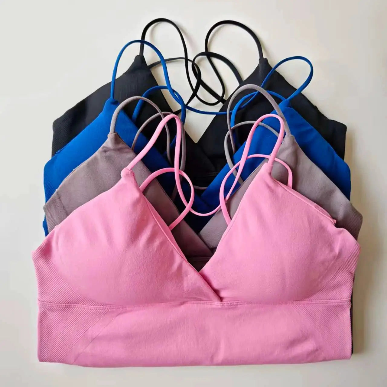 NCLAGEN Vision twist-front longline yoga top by Simples Market, pink with thin straps; assorted colors visible.