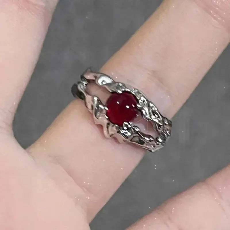 Goth punk open ring with red crystal centerpiece on finger; silver-tone twisted-band