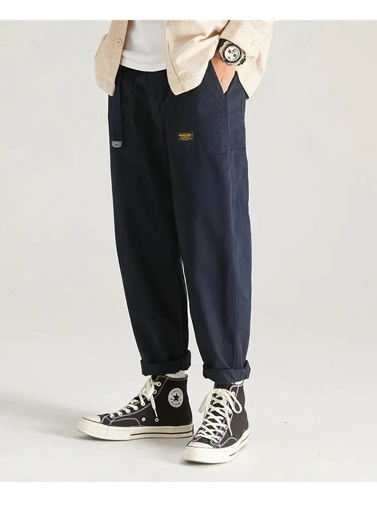 HIQOR men's navy cargo pants with multiple pockets; rolled cuffs, plus black Converse sneakers.