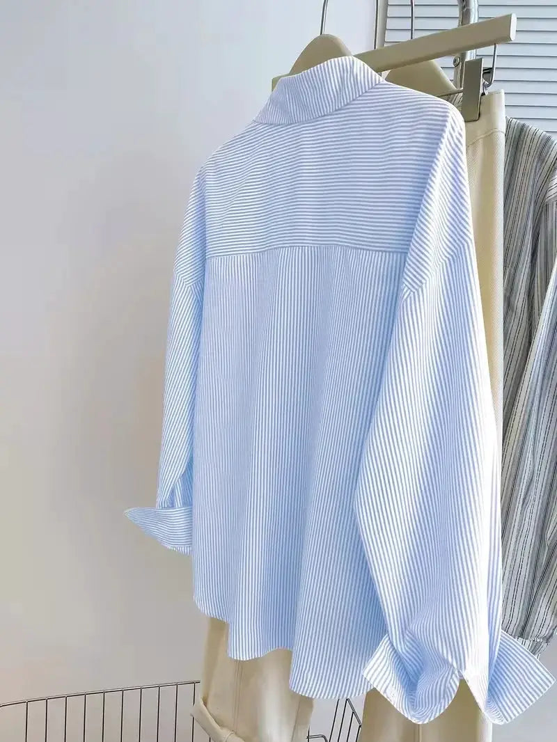 Women's striped long-sleeve blouse on hanger, light blue and white stripes, front button-up by Simples Market.