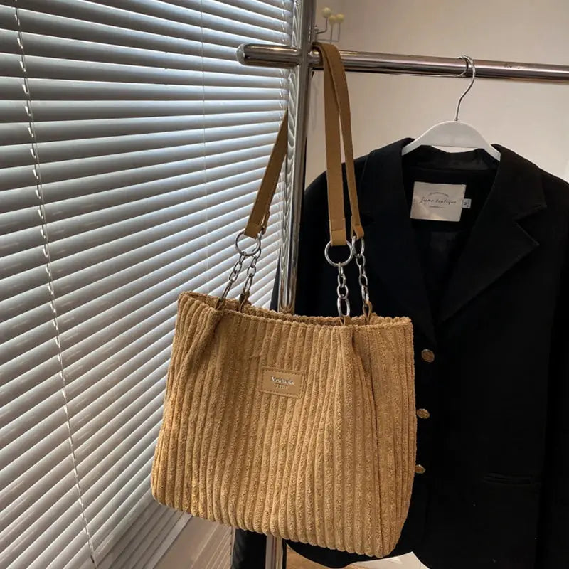 Women’s corduroy shoulder bag in beige with fixed strap and metal chain accents; large capacity casual tote