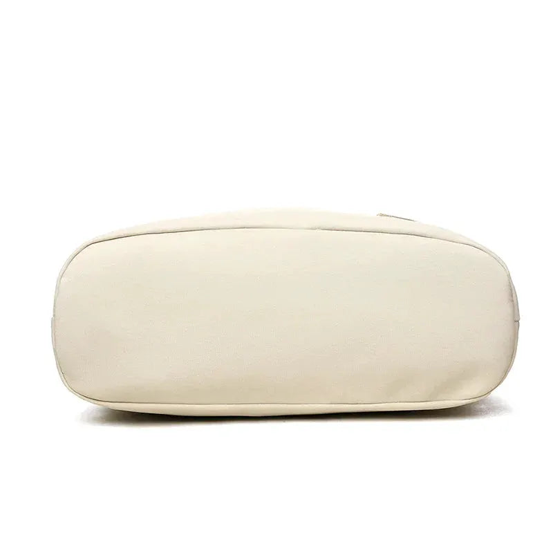 Crossbody bag in cream beige; bottom view of a canvas handbag with a rounded base