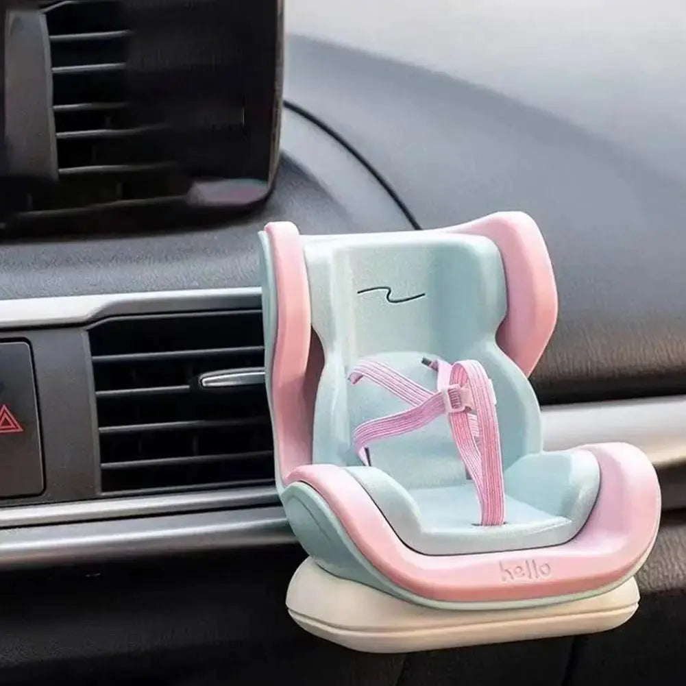 Car doll safety seat by kello for 17cm dolls, pastel blue with pink trim and pink harness, mounted on car dashboard