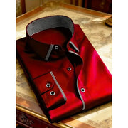 Red men's long-sleeve shirt with black striped collar and cuffs, folded on a table with square metal buttons