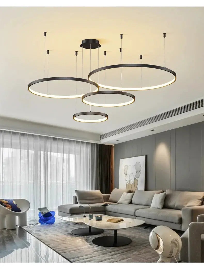 Minimalist black acrylic LED ring pendant lights, three circular chandeliers over a modern living room