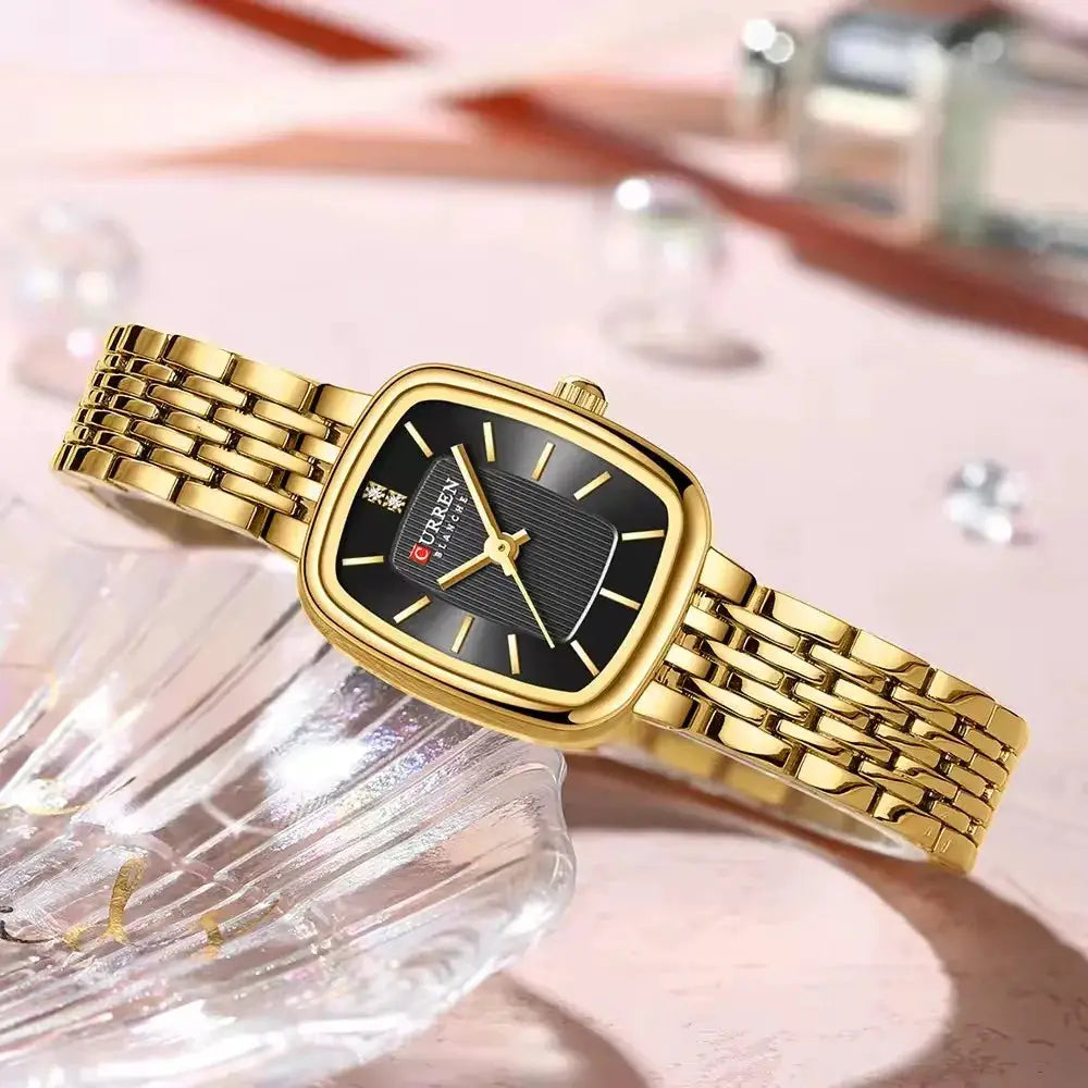 CURRN 9093 women's quartz watch with gold-tone stainless steel bracelet and black dial with diamond markers.