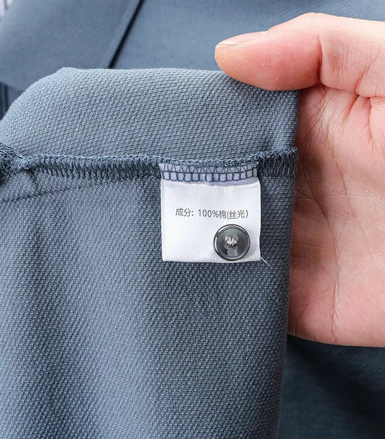 Blue short-sleeve polo shirt close-up reveals 100% cotton tag and a small button.