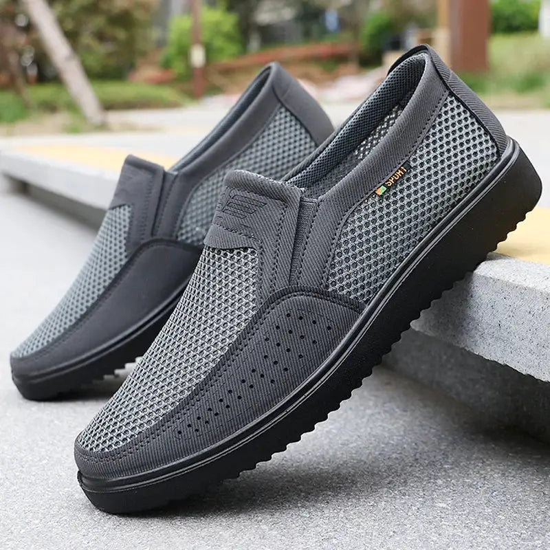 Pair of men's breathable slip-on casual shoes in gray mesh with rubber sole.